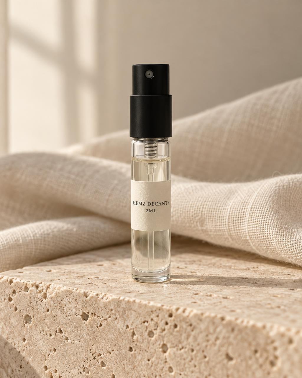 A clear 2ml glass spray atomiser with a black cap and an ivory HEMZ DECANTS 2ML label